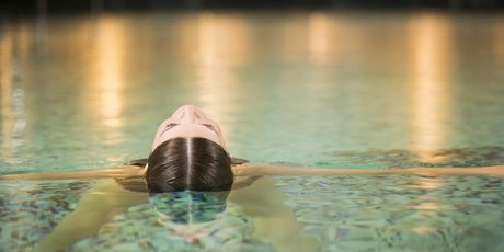 Eine Frau entspannt sich im Pool eines Day Spa