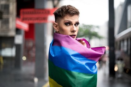 Drag Queen in Regenbogenflagge gehüllt