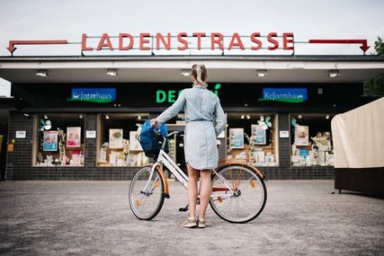 Fahrradfahrerin vor der Ladenstrasse des U-Bahnhof Onkel Toms Hütte Berlin