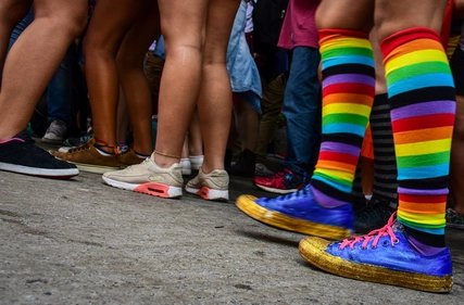 Person mit Regenbogensocken in Menschenmenge in Berlin