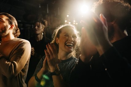 Lachende Frau applaudiert