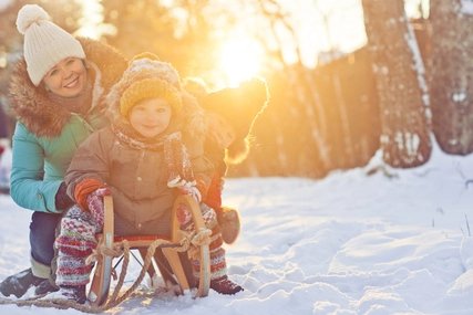 Mutter mit zwei Kindern auf einem Schlitten