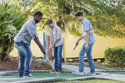 Jugendliche spielen Minigolf 