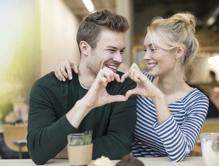 Pärchen im Cafe mit Herz-Händen