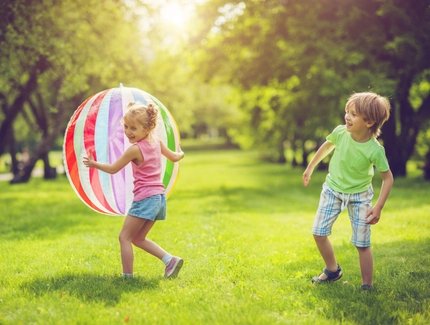 Junge und Mädchen spielen mit einem Ball