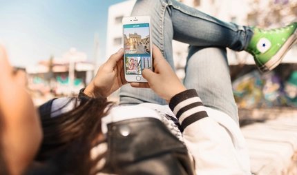 Junge Frau nutzt Streetart Highlight der ABOUT BERLIN App.