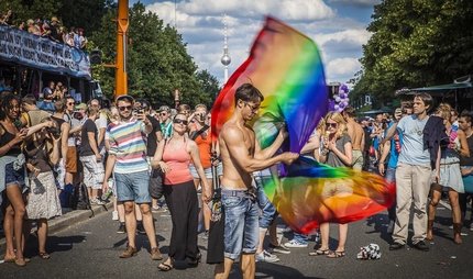 Menschen mit Regenbogenfahne auf dem CSD in Berlin