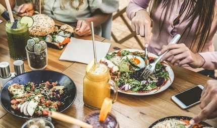 Hands view of young people eating brunch and drinking smoothies bowl with ecological straws in plastic free restaurant - Healthy lifestyle, food trends concept - Focus on top fork dish