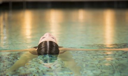 Eine Frau entspannt sich im Pool eines Day Spa