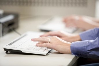 Tastatur im Call Center mit tippenden Händen