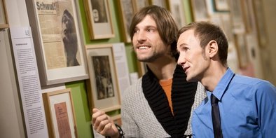 Zwei Männer schauen sich Bilder an im Schwulen Museum Berlin